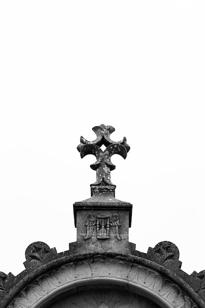 A cross on top of a building with the word cemetery on it.