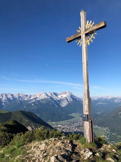 Foto croce in cima alla montagna contro il cielo blu