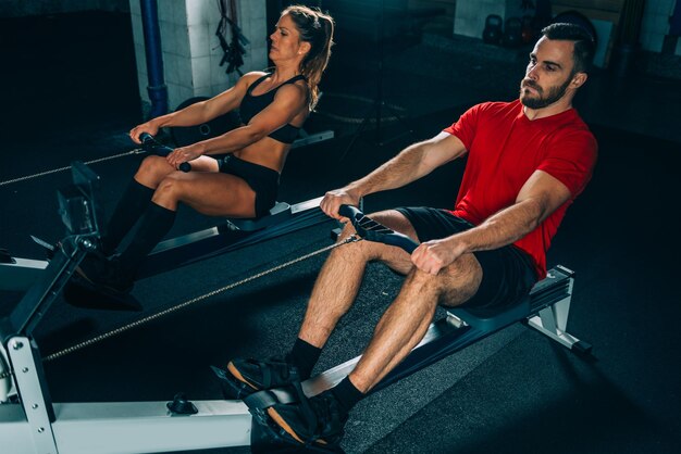 Photo cross training young athletes exercising on rowing machine