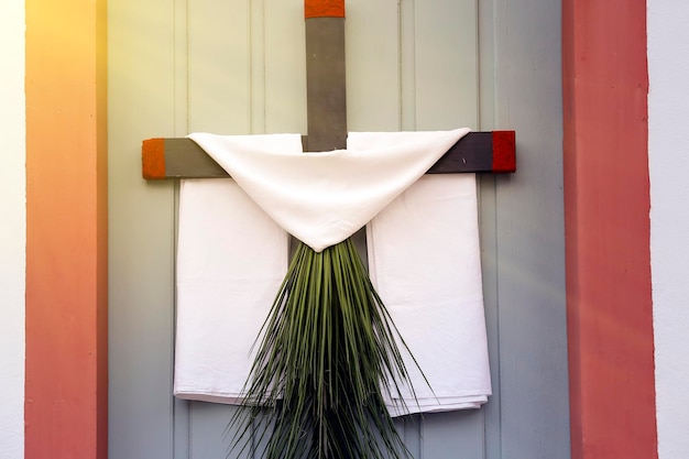 Cross with branches leaves and fabric during the celebration of Palm Sunday