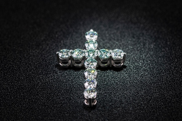 A cross with diamonds is on a black surface.