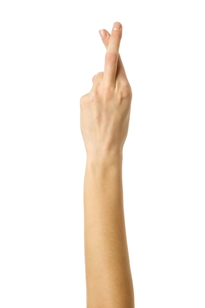 Crossed fingers. Woman hand with french manicure gesturing isolated on white background. Part of series