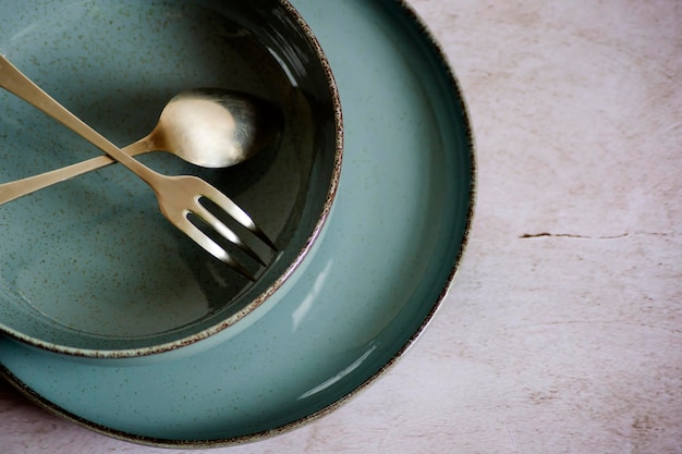 Crossed fork and spoon on an empty plate