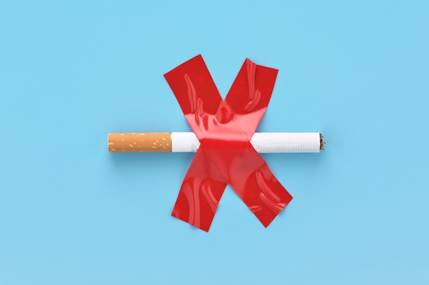 Crossed out cigarette, glued with red adhesive tape, no smoking concept.