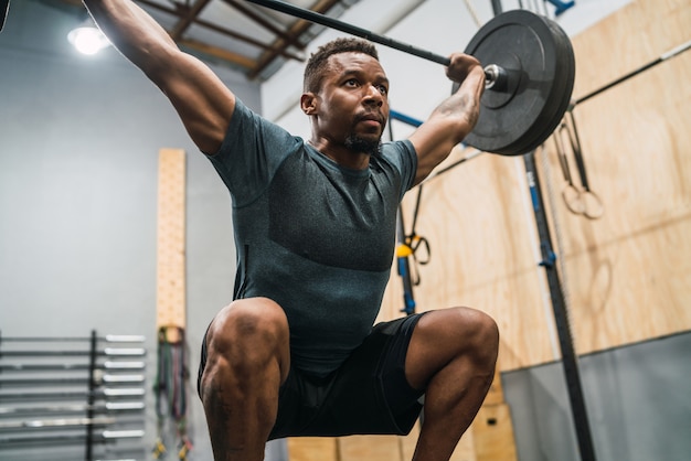 Crossfitatleet die oefening met een barbell doen.