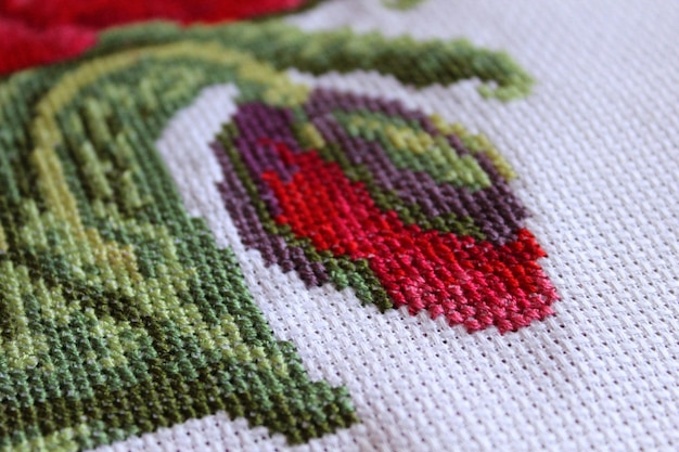 Foto crossstitch klaprozen op een witte canvas close-up geselecteerde focus