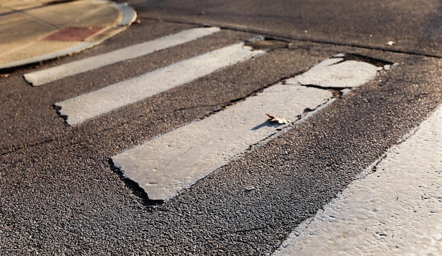 A crosswalk with a broken curb and a sign that says " no parking ".