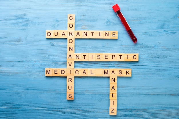 Crosswords on a medical theme on a wooden table. Pandemic quarantine concept