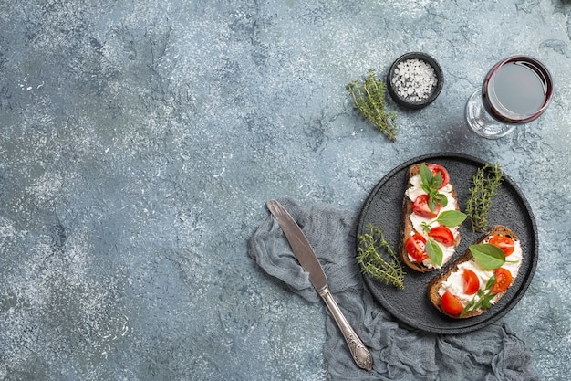 회색에 체리 토마토 바질과 치즈를 곁들인 Crostini 애피타이저