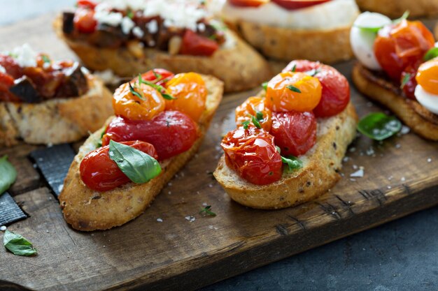 Photo crostini or bruschetta board with roasted tomatoes and herbs