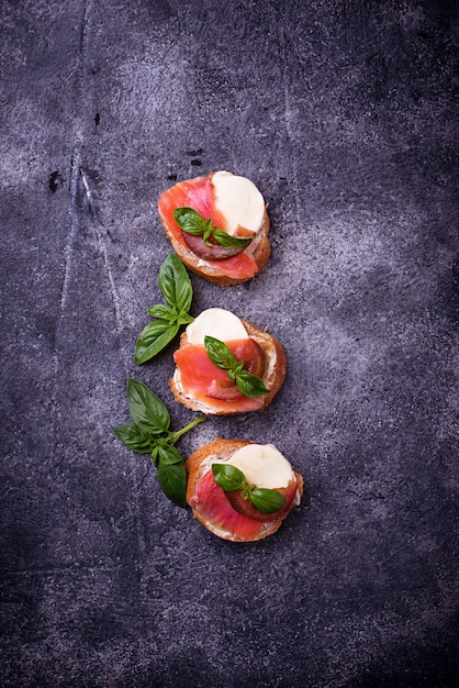 Crostini met zalm, mozarella, tomaat en basilicum. Italiaanse voorgerecht of voorgerecht