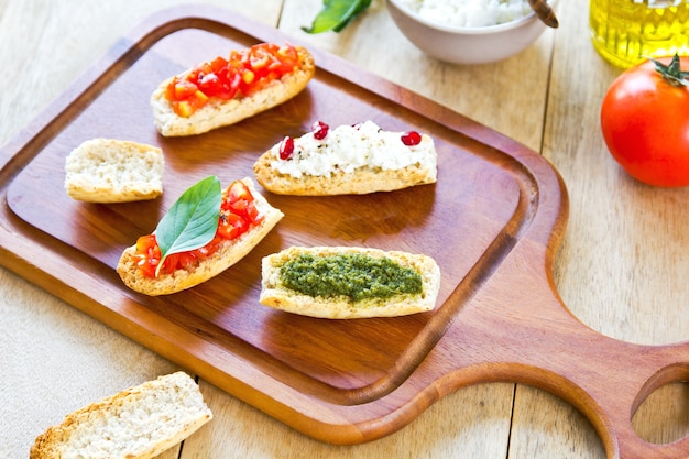 Crostini with Pesto, Cheese,and Tomato by some ingredients