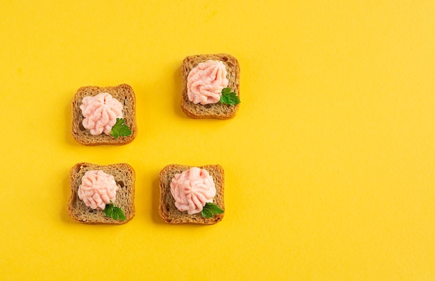 Crostini with tarama on the yellow background