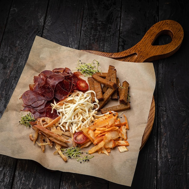 croutons, cheeses, smoked meat on a  wooden table