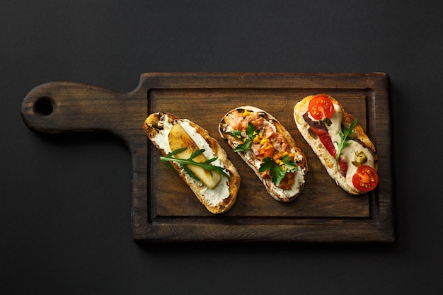 Foto crostini con salsa su un piatto nero isolato su sfondo nero