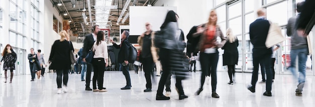 crowd of blurred business people rushing at a trade show, banner size, including copy space. ideal for websites and magazines layouts