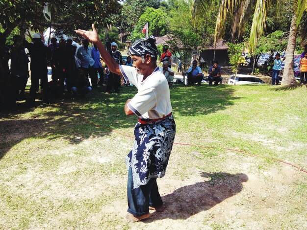 Photo crowd looking at senior man dancing on grassy field