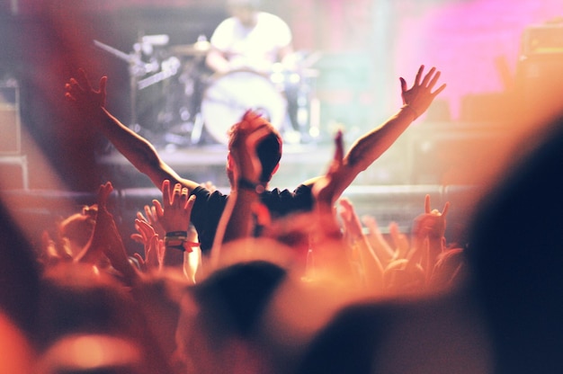 Crowd at a music concert audience raising hands up