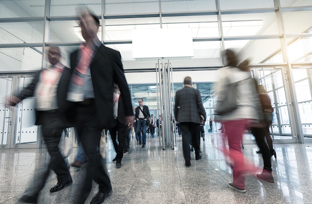 crowd of people rushing in a entrance at a trade show hall, including copy space banner. ideal for websites and magazines layouts