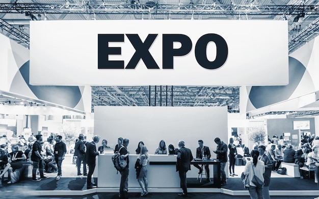 Crowd of people at a trade show booth with a banner and the\
text expo