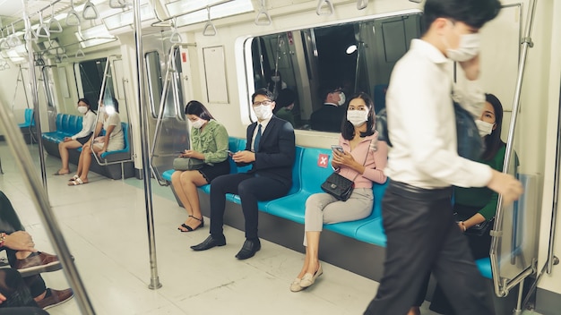 붐비는 대중 지하철 기차 여행에서 안면 마스크를 쓴 사람들의 군중