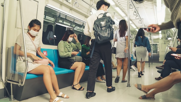 Crowd of people wearing face mask on a crowded public subway train travel