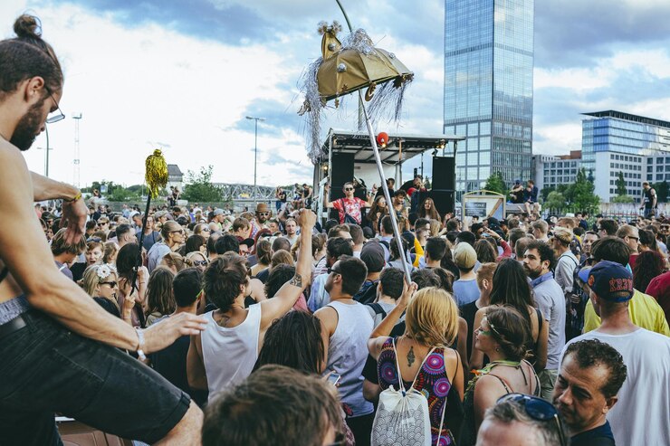 Photo crowd on street during music festival in city against sky