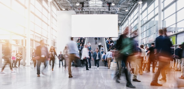 crowd of visitors rushing in a modern hall, including banner with copy space. ideal for websites and magazines layouts