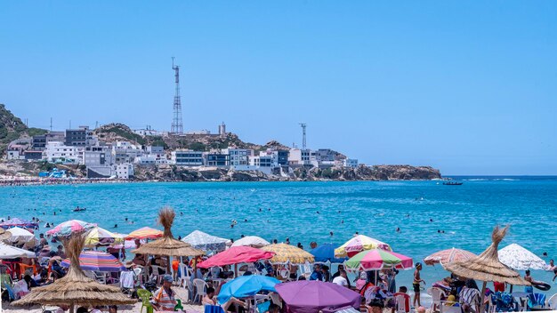 Photo crowded beach with umbrellas in ksar sghir morocco