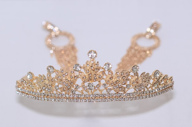 Photo a crown and earrings on a white background. the concept of a wedding, bridesmaid and bachelorette party.