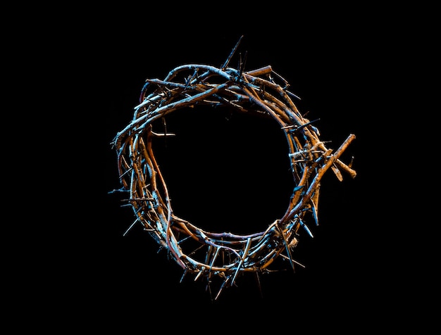 Crown of thorns with a blue tint of light in the dark. The concept of Holy Week, suffering and crucifixion of Jesus.
