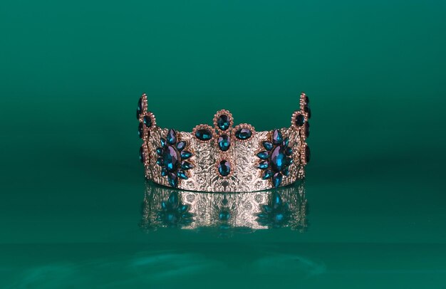 crown with precious stones isolated on green background