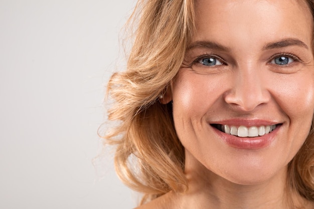 Crows feet concept closeup portrait of beautiful smiling female looking at camera