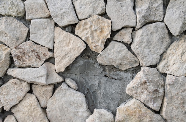 Стена из сырого цементированного известняка с щелью, от которой отвалился камень
