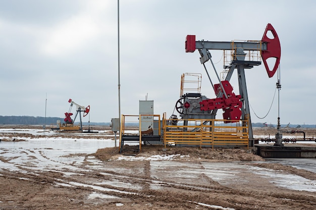 Crude oil pump jack at oilfield on sunset backround Fossil crude output and fuels oil production Oil drill rig and drilling derrick Global crude oil Prices energy petroleum demand