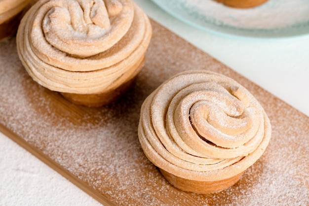 Cruffins Pasen-lentegebakjes, muffin en croissantbroodje op een lichte achtergrond, close-up voor tekstplaats. verse zelfgemaakte feestelijke kulich.