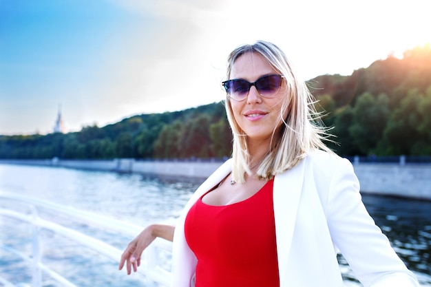 Cruise boat vacation young pretty woman in sunglasses relaxing\
on deck enjoying view from boat happy casual tourist girl on\
holiday destination