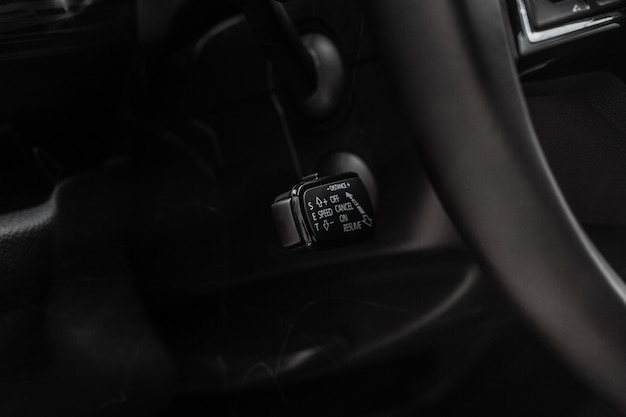 Cruise control switch closeup. Adaptive cruise control leaver. Cruise control on steering wheel.