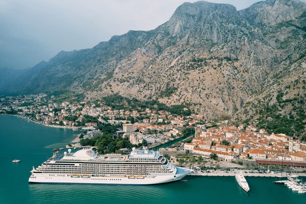 Foto cruise schip staat voor de kust van kotor met bergen op de achtergrond montenegro drone