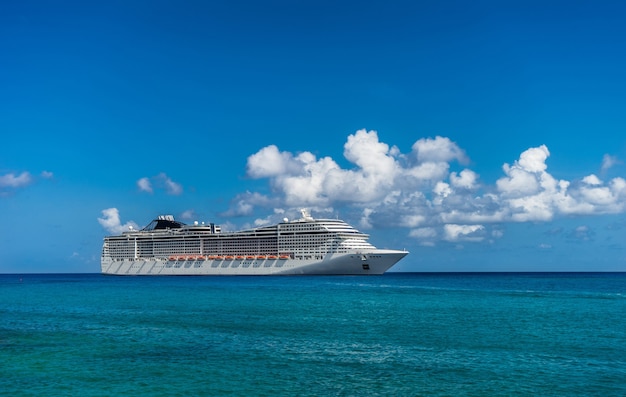 Photo cruise ship in crystal blue water with a pirate and pirate flag on the front.