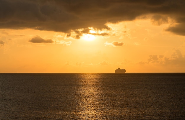 Cruise ship on horizon at sunset