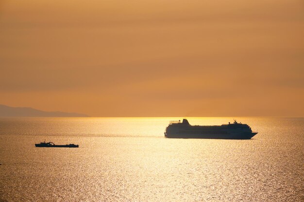 Cruise ship silhouette in aegean sea on sunset