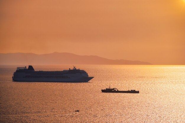 Cruise ship silhouette in Aegean sea on sunset