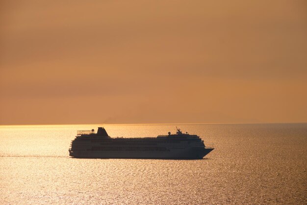 Cruise ship silhouette in Aegean sea on sunset