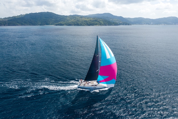 Cruise vakantie. luchtfotografie van jacht met roze zeil op zeewater