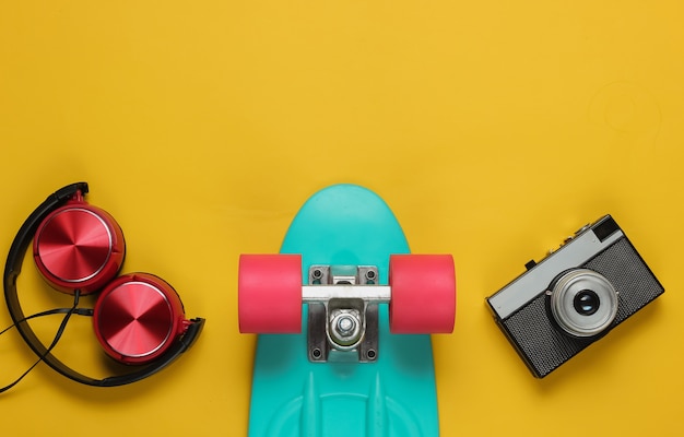 Cruiser board headphones film camera on yellow background