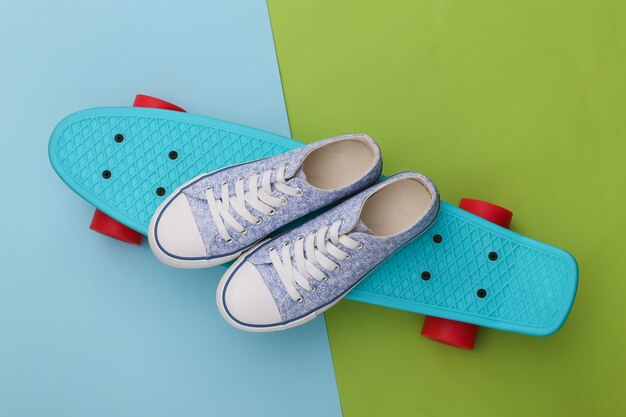 Cruiser board met sneakers op groen blauw. Jeugd entertainment. Hipster-outfit