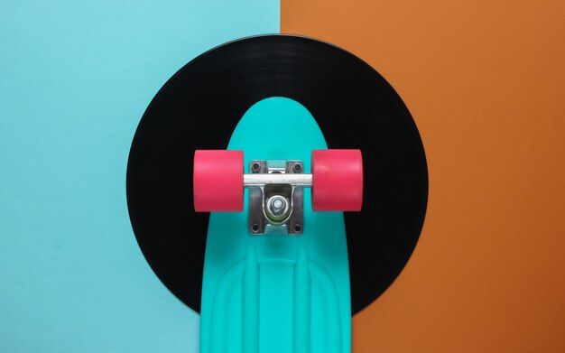 Cruiser board on vinyl record. Brown blue background. Youth retro style concept.