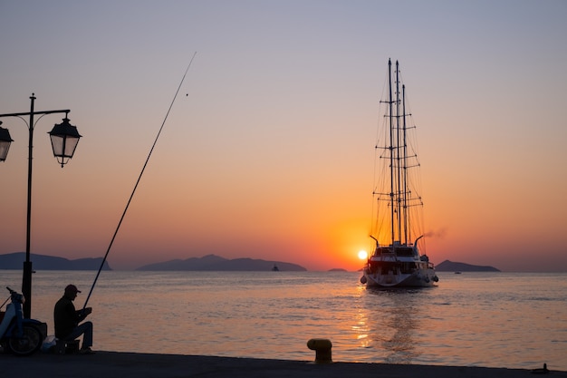 Cruiseschip vaart tegen een achtergrond van oranje zonsondergang