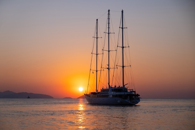 Cruiseschip vaart tegen een achtergrond van oranje zonsondergang